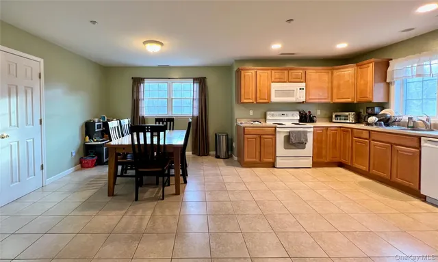 a kitchen with stainless steel appliances granite countertop a table and chairs in it
