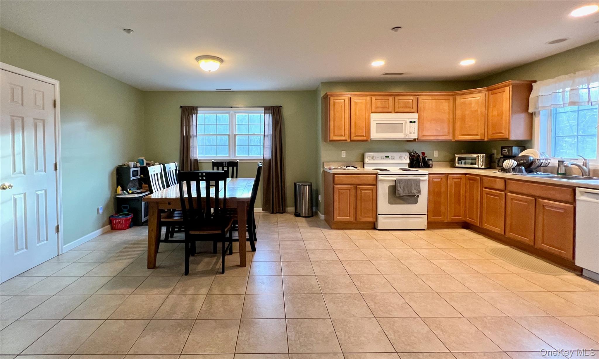 a kitchen with stainless steel appliances granite countertop a table and chairs in it
