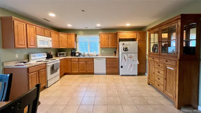 a kitchen with stainless steel appliances granite countertop a stove top oven a sink a refrigerator and cabinets