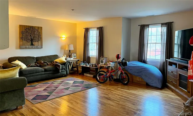 a living room with furniture a flat screen tv and a window