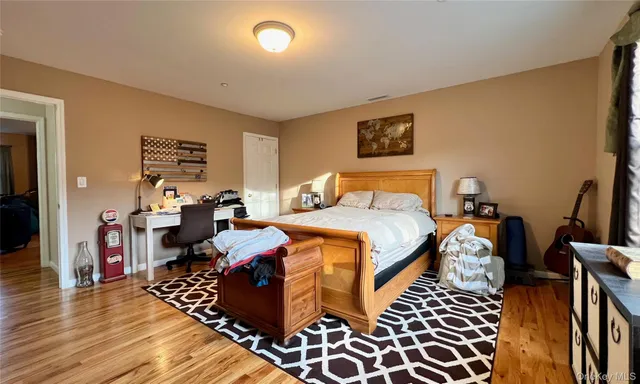 a bedroom with bed and wooden floor