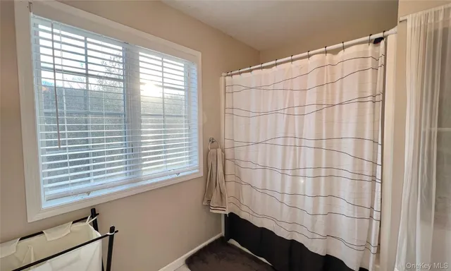 a bathroom with a shower curtain and a window