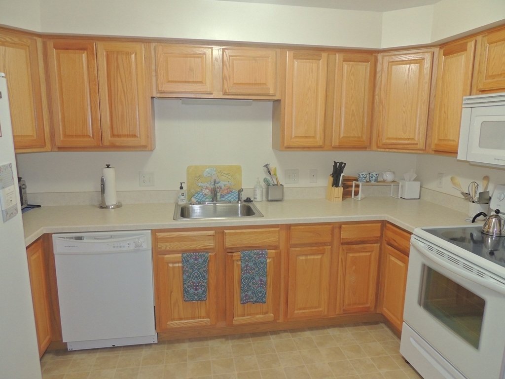 26 Greenleaves Drive, Unit 635 Amherst, MA 01002 - Photo 5 of 11 a kitchen with stainless steel appliances granite countertop white cabinets a sink and dishwasher