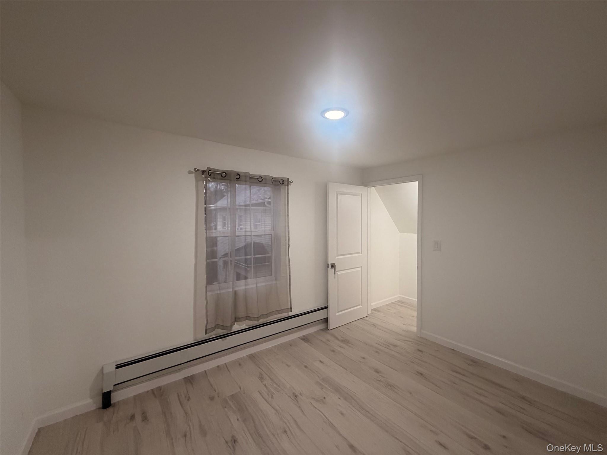 79 Monhagen Avenue Middletown, NY 10940 - Photo 16 of 22 an empty room with wooden floor and windows