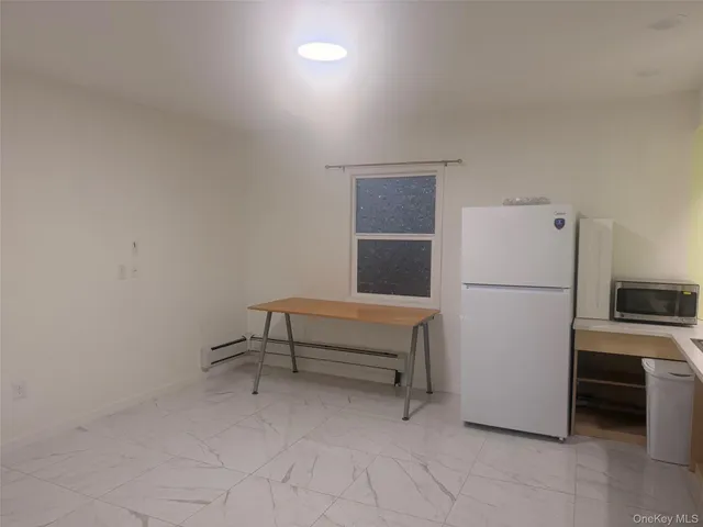 a bedroom with a bed and a refrigerator