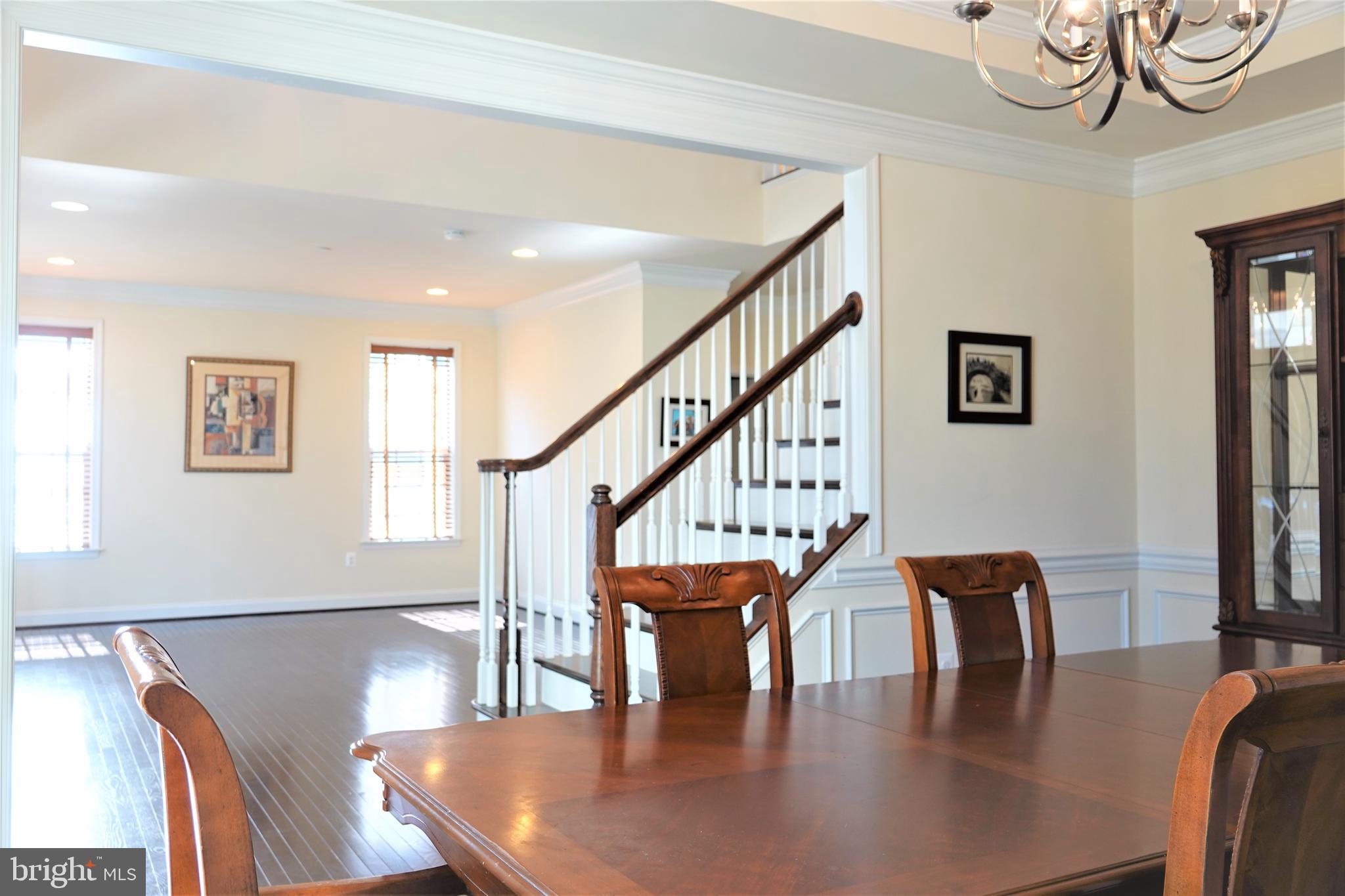 6606 Pyle Road Bethesda, MD 20817 - Photo 3 of 29 a dining room with wooden floor a glass table and chairs