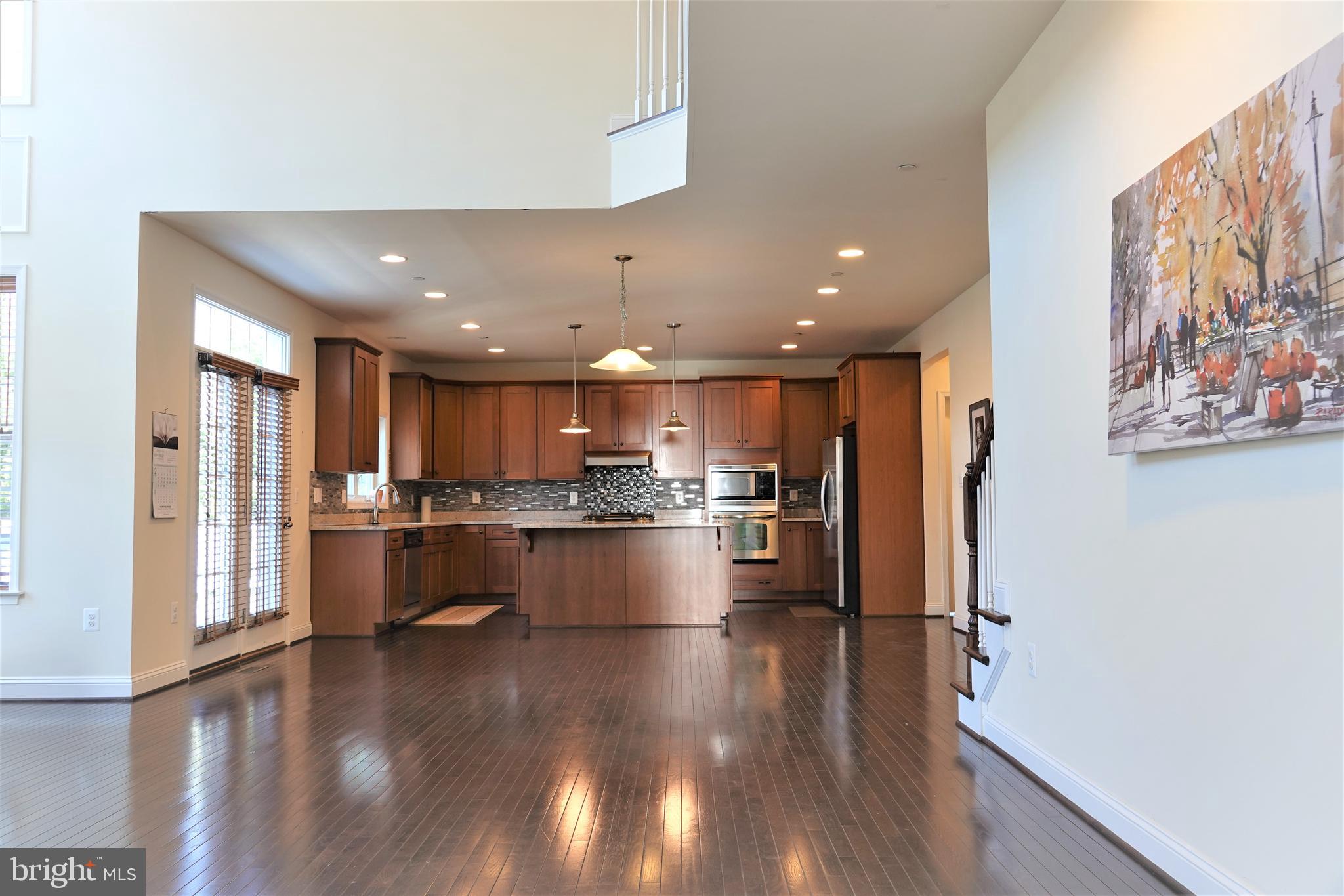 6606 Pyle Road Bethesda, MD 20817 - Photo 7 of 29 a open kitchen with stainless steel appliances granite countertop a refrigerator a sink dishwasher a stove and white countertops with wooden floor
