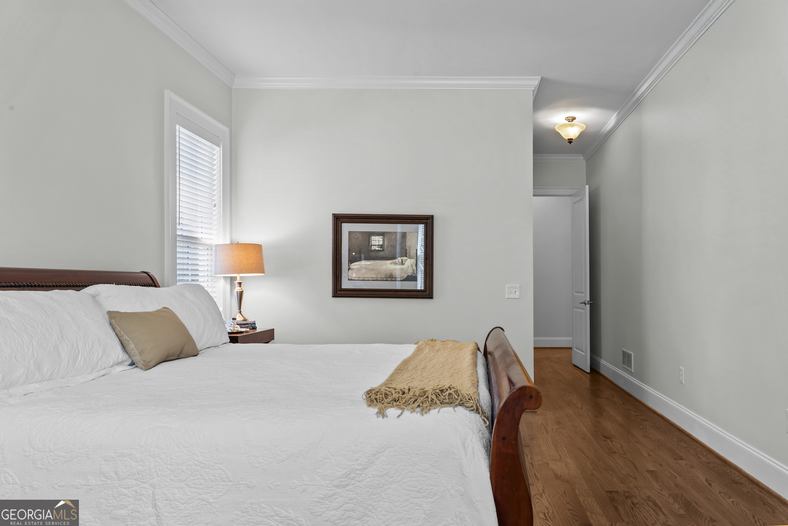 568 New Post Road Madison, GA 30650 - Photo 26 of 58 a bedroom with a bed and a lamp