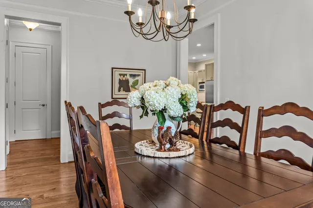 a dining room with furniture a chandelier and wooden floor