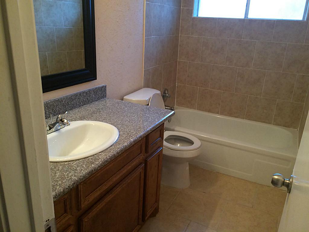 16826 Rippling Mill Drive Sugar Land, TX 77498 - Photo 9 of 18 a bathroom with a granite countertop sink toilet and shower
