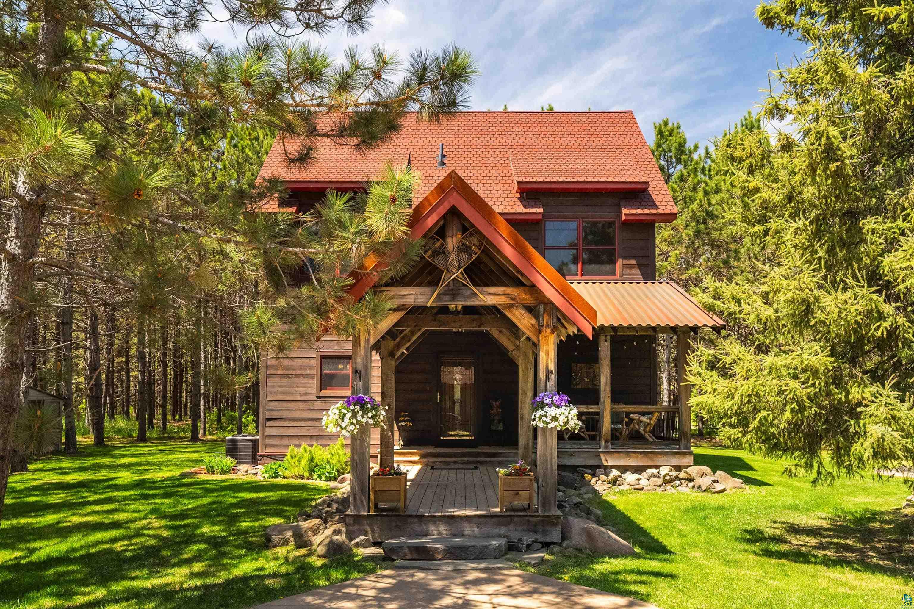 75 East Stark Road Esko, MN 55733 - Photo 52 of 87 Rustic-style home featuring a prominent wood beam entry, red shingle roofing, and dark wood siding