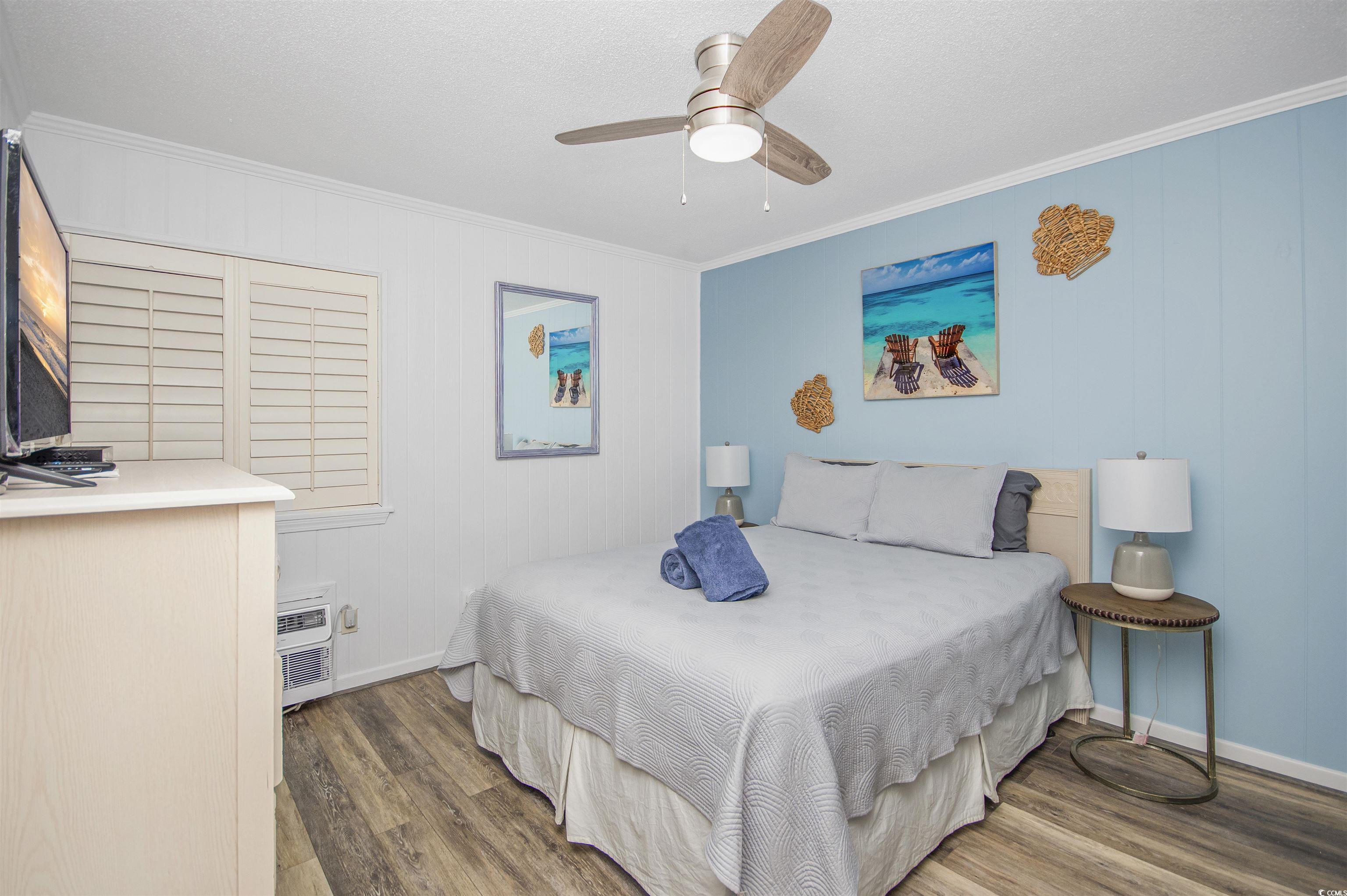 9530 Shore Drive, Unit 2D Myrtle Beach, SC 29572 - Photo 13 of 25 Bedroom featuring ornamental molding, wood finished floors, a ceiling fan, and a textured ceiling