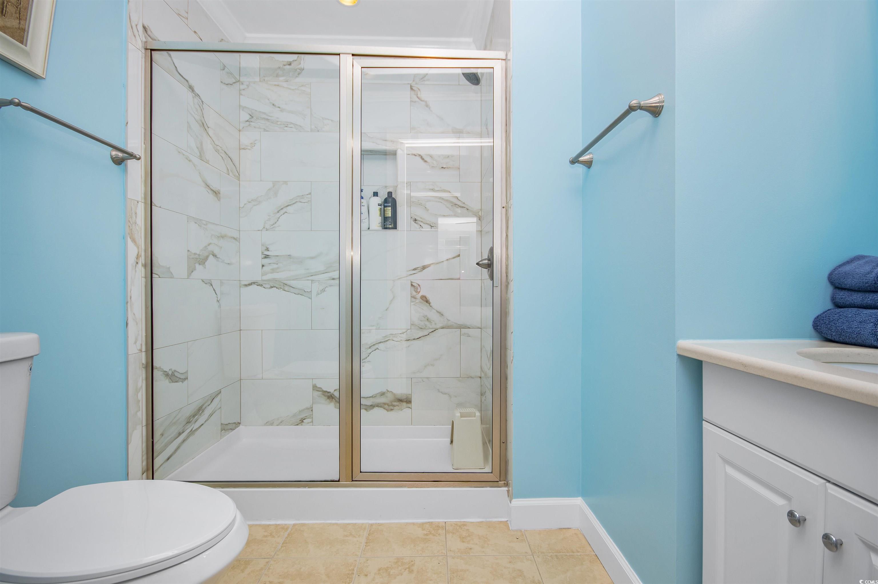 9530 Shore Drive, Unit 2D Myrtle Beach, SC 29572 - Photo 17 of 25 Full bath with vanity, a marble finish shower, and light tile patterned flooring