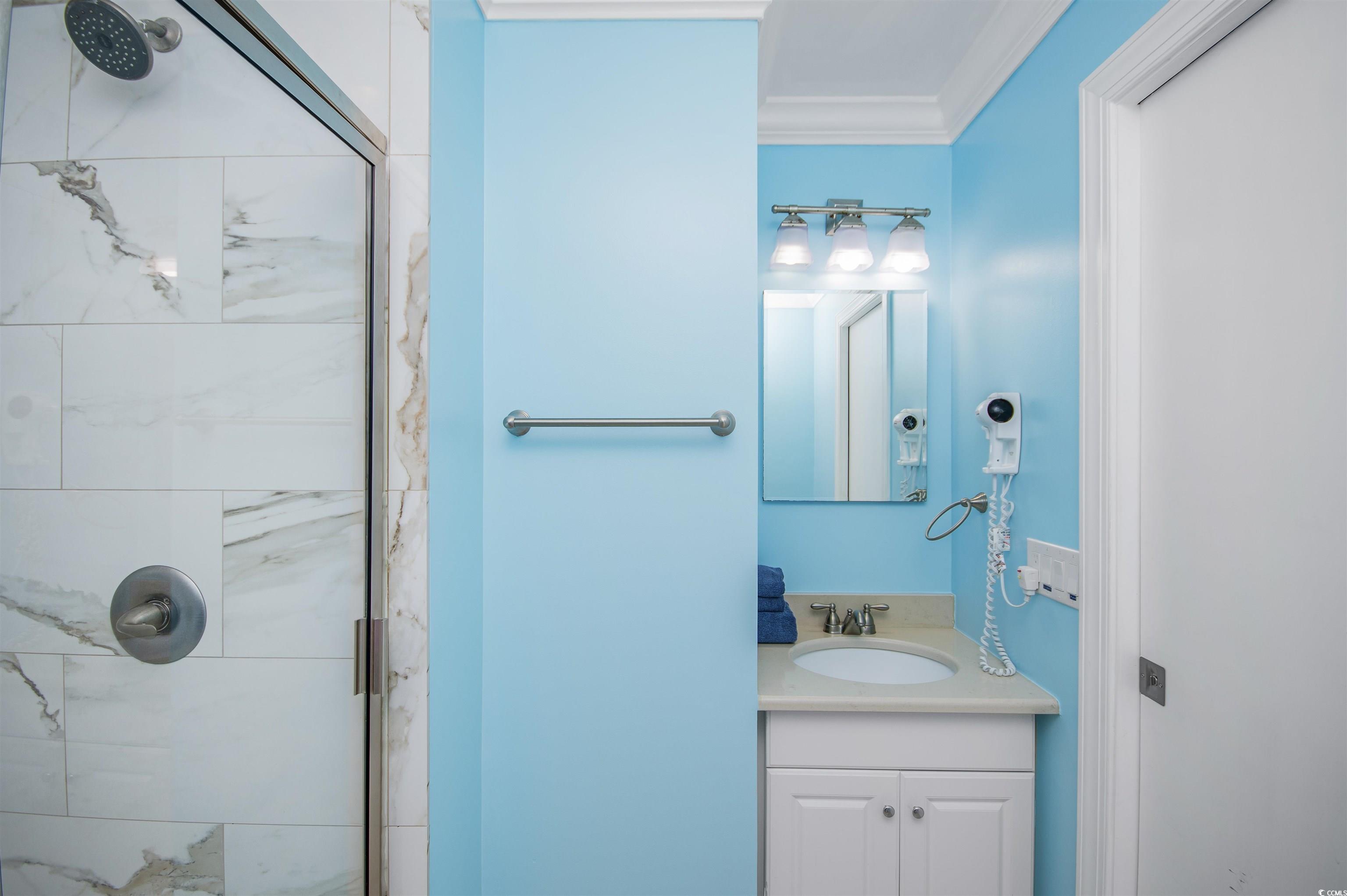 9530 Shore Drive, Unit 2D Myrtle Beach, SC 29572 - Photo 18 of 25 Full bathroom with a shower stall, ornamental molding, and vanity