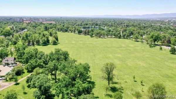 an aerial view of residential houses with outdoor space and trees