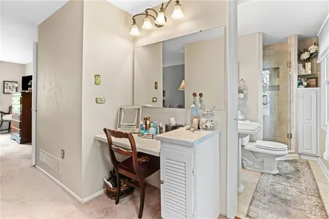 a view of a bathroom with a toilet a sink and a mirror