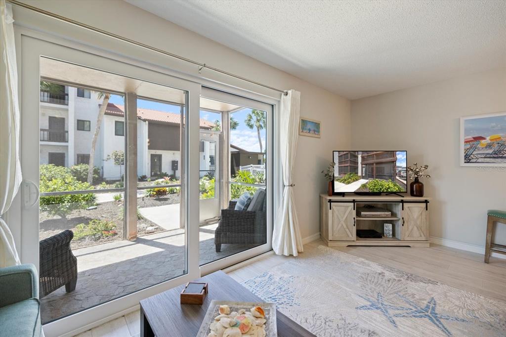 1604 Stickney Point Road, Unit 4102 Sarasota, FL 34231 - Photo 11 of 30 a living room with furniture a flat screen tv and a fireplace