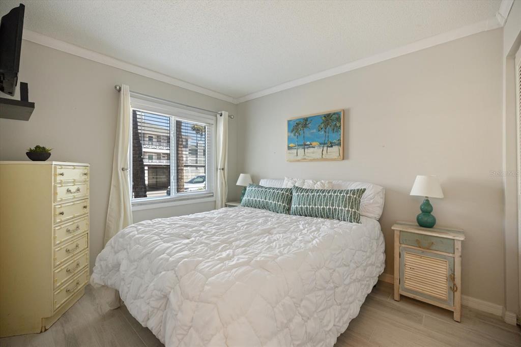 1604 Stickney Point Road, Unit 4102 Sarasota, FL 34231 - Photo 13 of 30 a bedroom with a bed and a tv on the dresser