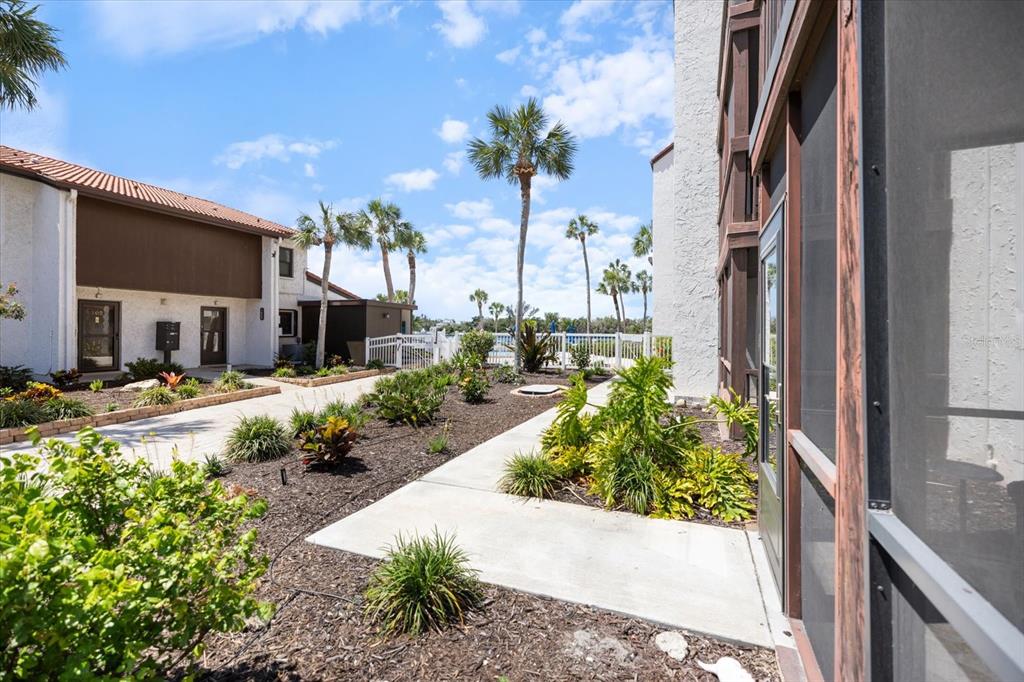 1604 Stickney Point Road, Unit 4102 Sarasota, FL 34231 - Photo 18 of 30 a view of a house with a yard and potted plants