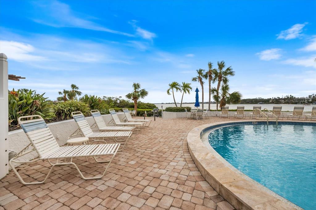 1604 Stickney Point Road, Unit 4102 Sarasota, FL 34231 - Photo 22 of 30 a view of swimming pool with outdoor seating and plants