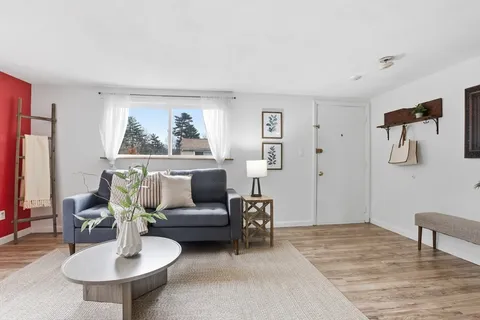 a living room with furniture and a painting on the wall