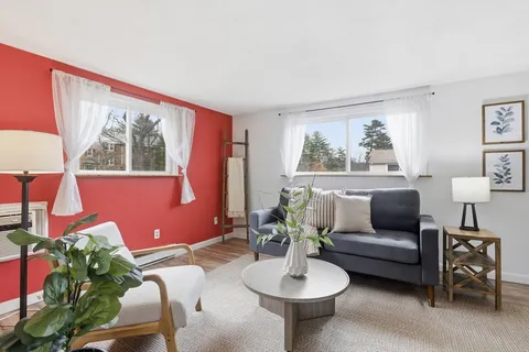 a living room with furniture and a painting on the wall