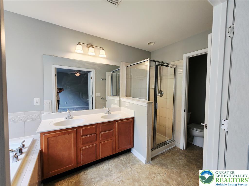 8513 Gateway Road Breinigsville, PA 18031 - Photo 29 of 45 A well-appointed primary bathroom features dual vanities, a separate shower, and a soaking tub.