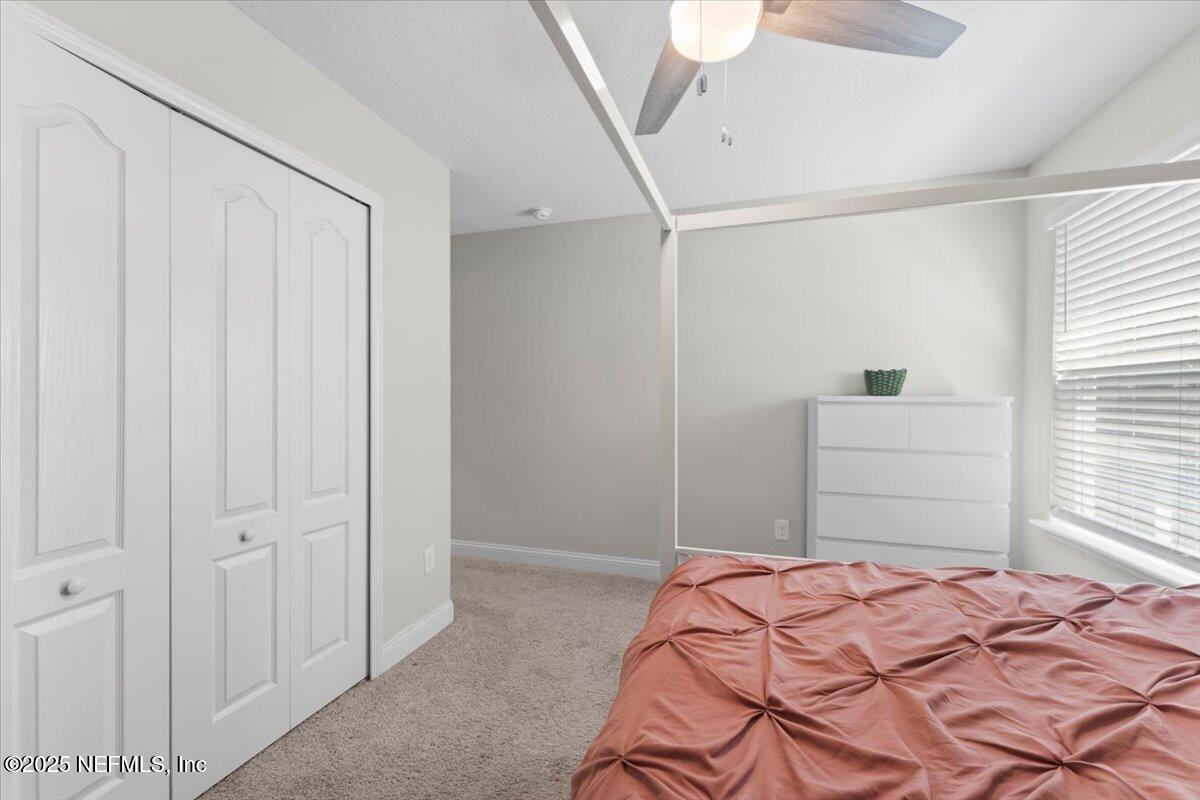 3060 Free Bird Loop Green Cove Springs, FL 32043 - Photo 25 of 94 a bedroom with a bed and a chandelier fan