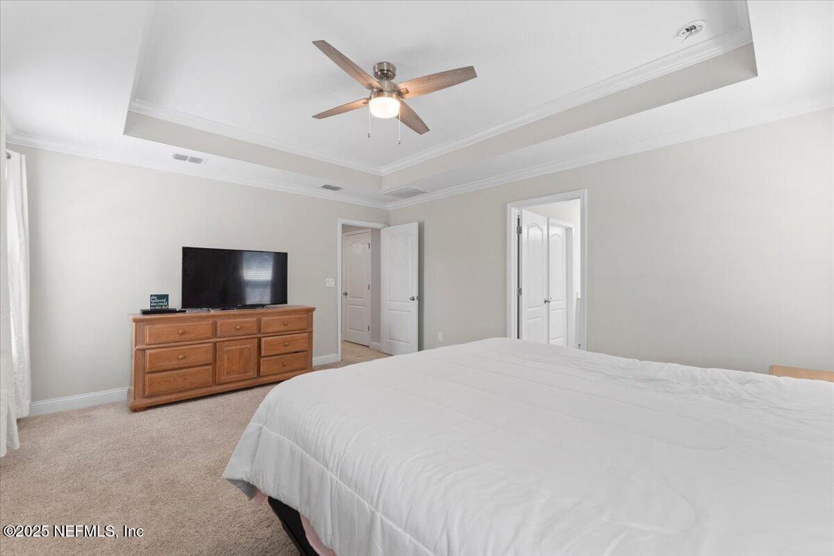 3060 Free Bird Loop Green Cove Springs, FL 32043 - Photo 30 of 94 a bedroom with a large bed a flat screen tv and a window