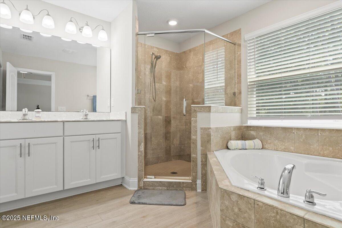 3060 Free Bird Loop Green Cove Springs, FL 32043 - Photo 33 of 94 a bathroom with a tub a sink and a large mirror
