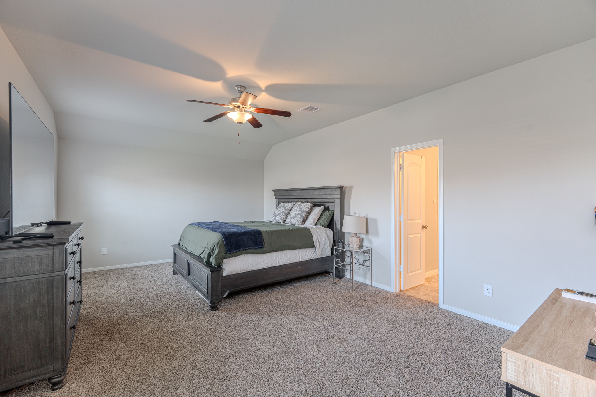 14207 Irvine Rnch Trail Conroe, TX 77384 - Photo 17 of 29 a bedroom with a bed and a chandelier