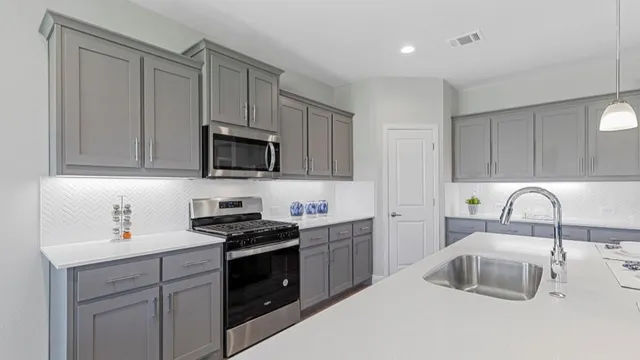 a kitchen with stainless steel appliances kitchen island granite countertop a table chairs sink and cabinets