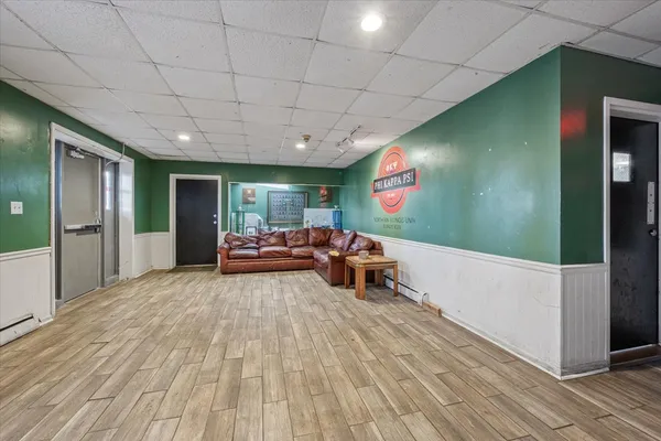 a view of living room kitchen with stainless steel appliances wooden floor and window