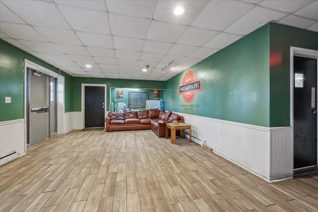 a view of living room kitchen with stainless steel appliances wooden floor and window