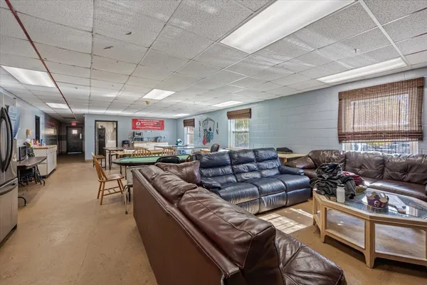 a living room with furniture kitchen view and a window