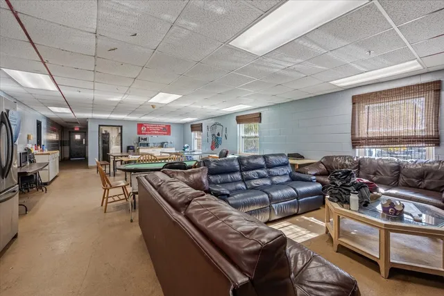 a living room with furniture kitchen view and a window
