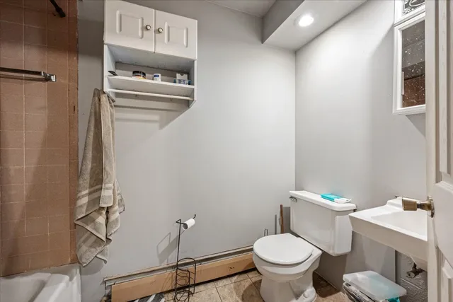 a white toilet sitting next to a bathroom sink and a vanity