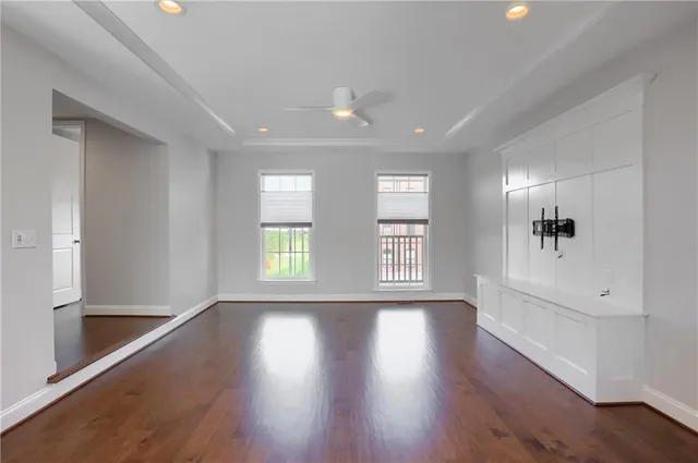a view of an empty room with a window and wooden floor