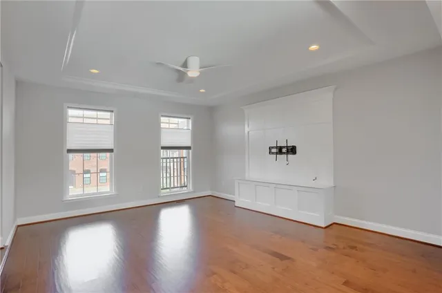 an empty room with wooden floor and windows