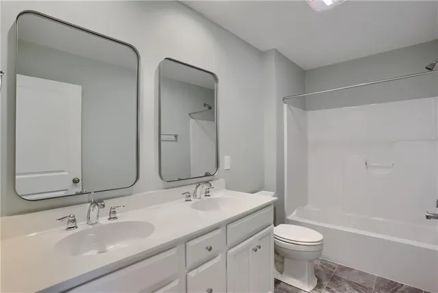 a bathroom with a toilet a sink a mirror a bathtub and vanity