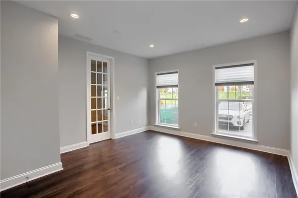 an empty room with wooden floor and windows