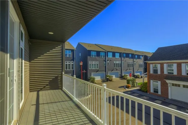 a view of a balcony with two chairs and potted plants