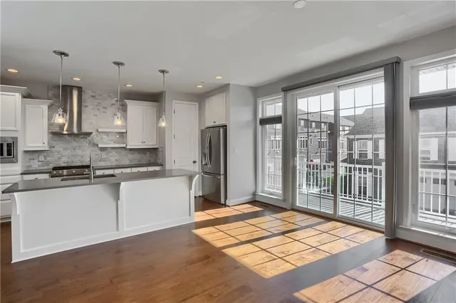 a kitchen with stainless steel appliances granite countertop a refrigerator and a sink