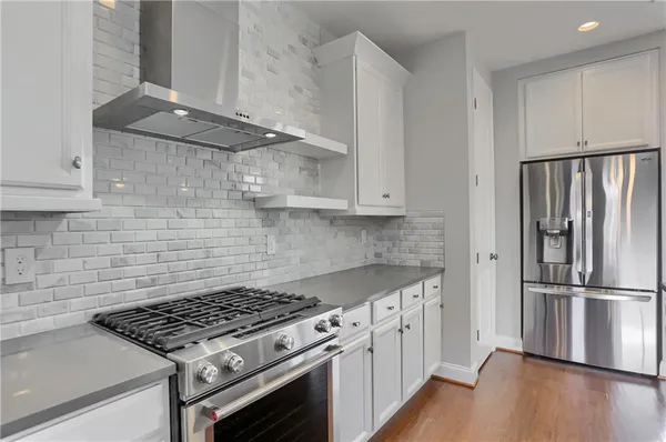 a kitchen with granite countertop stainless steel appliances a counter space and wooden floor