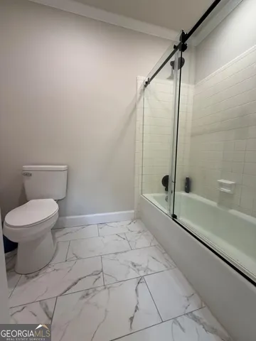 a bathroom with a toilet and a shower