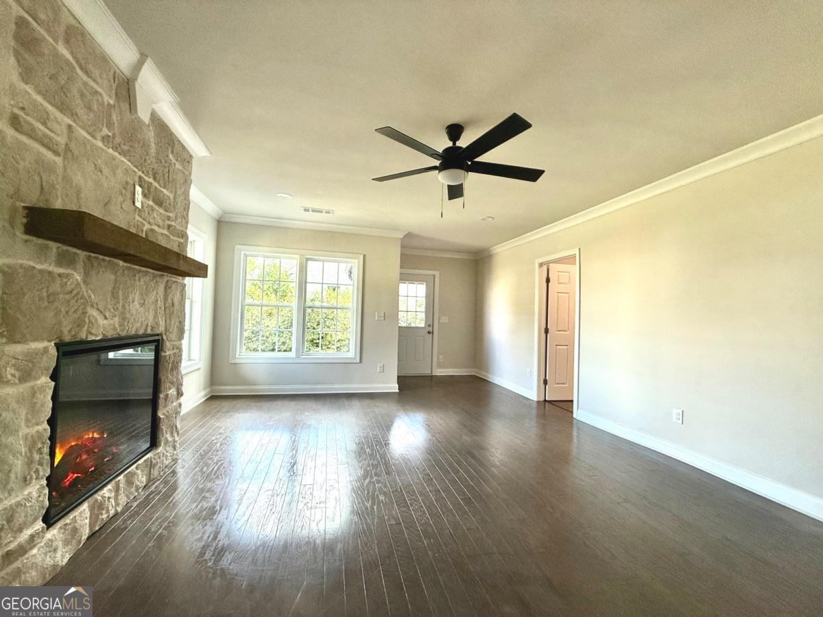 213 Fair Street Baxley, GA 31513 - Photo 4 of 29 a view of a room with wooden floor and a fireplace