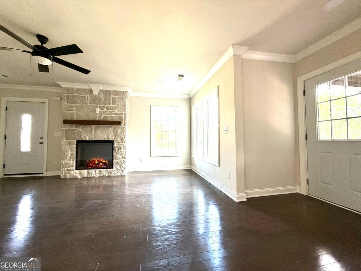 213 Fair Street Baxley, GA 31513 - Photo 5 of 29 a view of a livingroom with wooden floor a fireplace and window