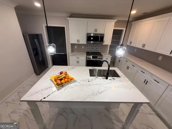a kitchen with stainless steel appliances kitchen island granite countertop a sink a stove counter space and microwave
