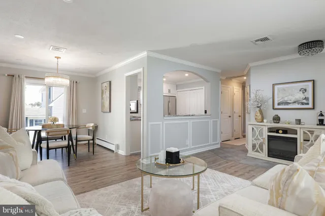 a living room with furniture a dining table and kitchen view