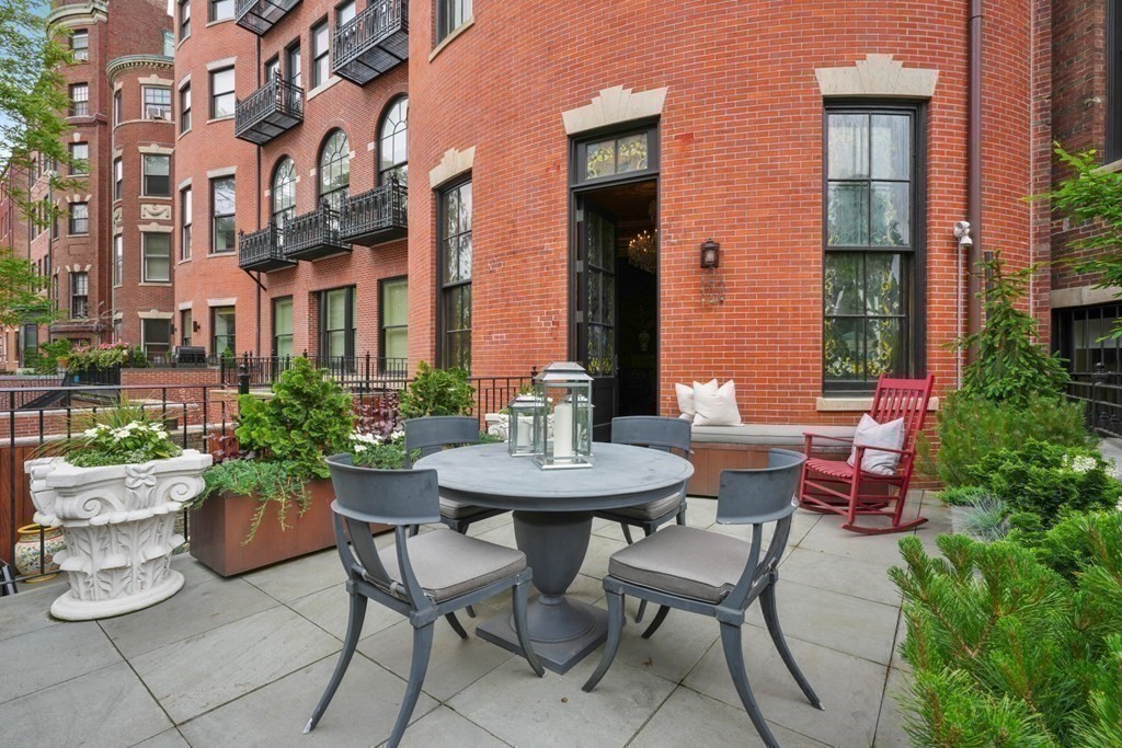 a view of a patio with a table and chairs and potted plants